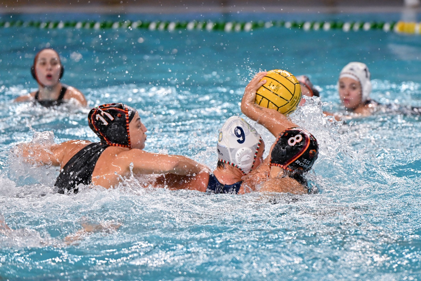 Azione di gioco tra attaccanti e difensori durante una partita di pallanuoto